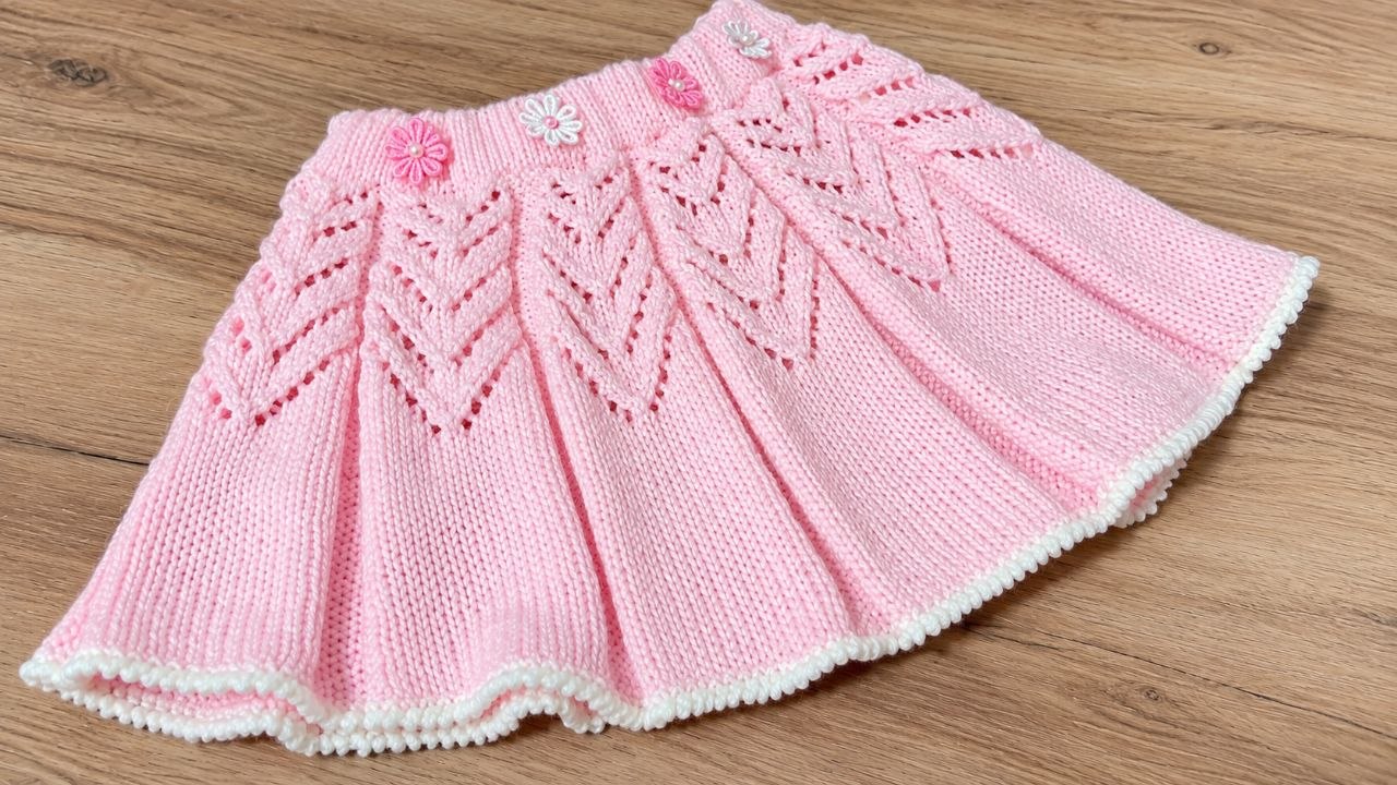 Falda infantil rosa tejida a dos agujas con doce secciones caladas